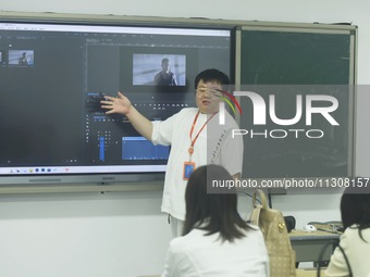 A teacher is teaching students how to make short videos in a classroom in Hangzhou, China, on June 5, 2024. (