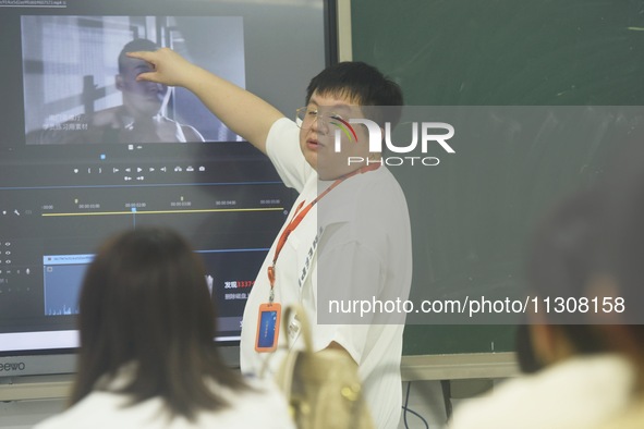 A teacher is teaching students how to make short videos in a classroom in Hangzhou, China, on June 5, 2024. 