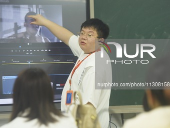 A teacher is teaching students how to make short videos in a classroom in Hangzhou, China, on June 5, 2024. (