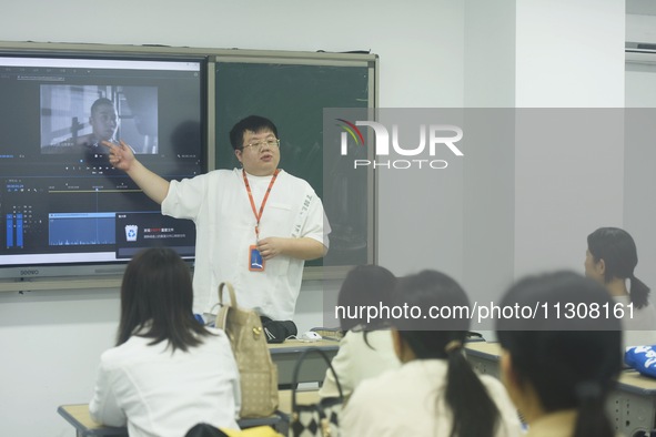 A teacher is teaching students how to make short videos in a classroom in Hangzhou, China, on June 5, 2024. 