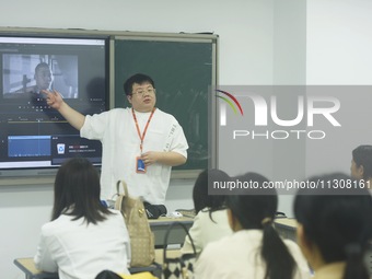 A teacher is teaching students how to make short videos in a classroom in Hangzhou, China, on June 5, 2024. (