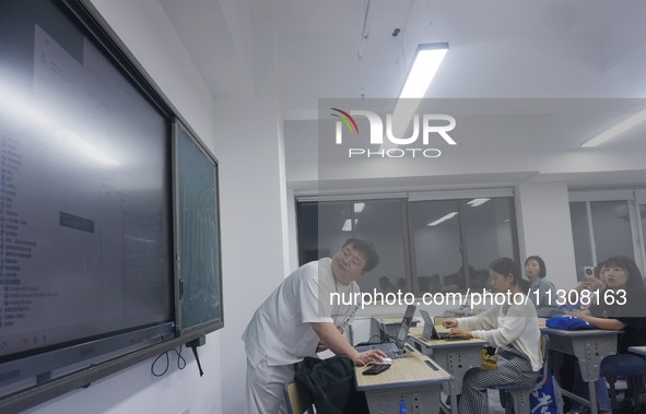 A teacher is teaching students how to make short videos in a classroom in Hangzhou, China, on June 5, 2024. 