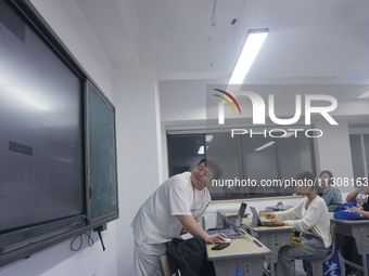 A teacher is teaching students how to make short videos in a classroom in Hangzhou, China, on June 5, 2024. (