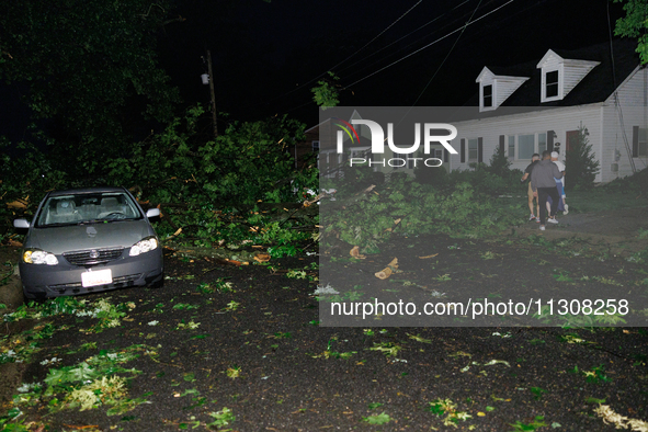 Residents of a Gaithersburg, Maryland neighborhood gather to survey damage on June 5, 2024, after a tornado swept through the region. 