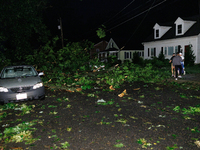 Residents of a Gaithersburg, Maryland neighborhood gather to survey damage on June 5, 2024, after a tornado swept through the region. (