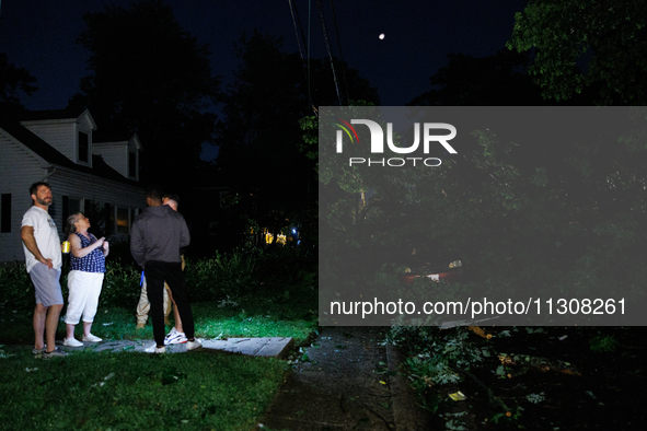 Residents of a Gaithersburg, Maryland neighborhood gather to survey damage on June 5, 2024, after a tornado swept through the region. 