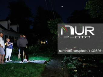 Residents of a Gaithersburg, Maryland neighborhood gather to survey damage on June 5, 2024, after a tornado swept through the region. (