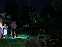 Residents of a Gaithersburg, Maryland neighborhood gather to survey damage on June 5, 2024, after a tornado swept through the region. (