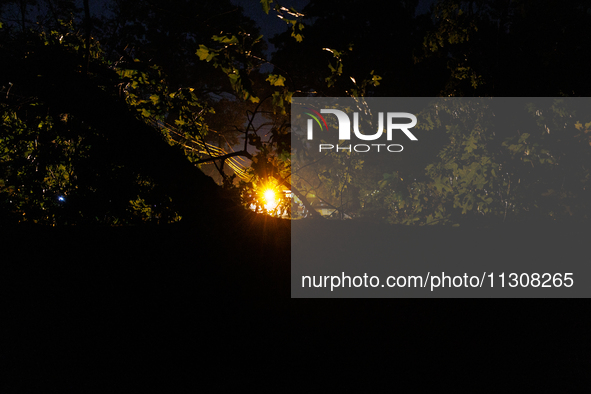 A utility repair vehicle's light is seen beyond a fallen tree in a Gaithersburg, Maryland neighborhood on June 5, 2024, after a tornado swep...