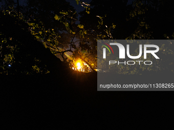 A utility repair vehicle's light is seen beyond a fallen tree in a Gaithersburg, Maryland neighborhood on June 5, 2024, after a tornado swep...