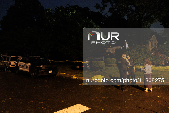 A resident talks with police after a tornado swept through a Gaithersburg, Maryland neighborhood on June 5, 2024. 