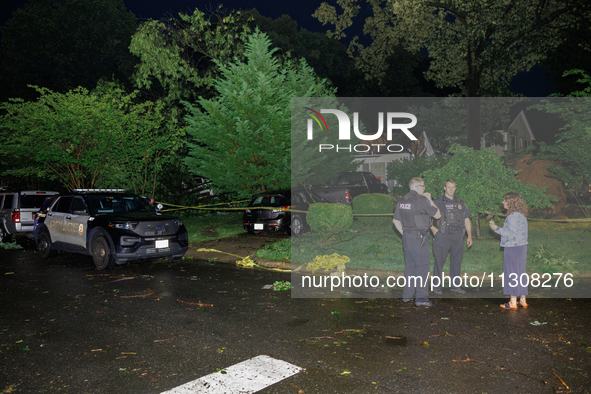 A resident talks with police after a tornado swept through a Gaithersburg, Maryland neighborhood on June 5, 2024. 