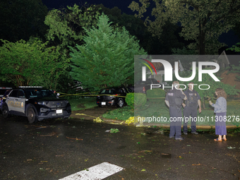 A resident talks with police after a tornado swept through a Gaithersburg, Maryland neighborhood on June 5, 2024. (