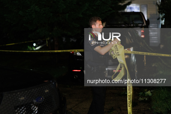 A police officer gathers police line tape after a tornado swept through a Gaithersburg, Maryland neighborhood on June 5, 2024. 