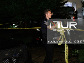 A police officer gathers police line tape after a tornado swept through a Gaithersburg, Maryland neighborhood on June 5, 2024. (