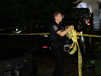 A police officer gathers police line tape after a tornado swept through a Gaithersburg, Maryland neighborhood on June 5, 2024. (