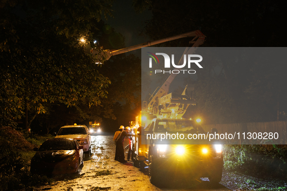 Utility crews make repairs in a Gaithersburg, Maryland neighborhood on June 5, 2024, after a tornado swept through the region. 