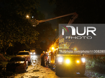 Utility crews make repairs in a Gaithersburg, Maryland neighborhood on June 5, 2024, after a tornado swept through the region. (