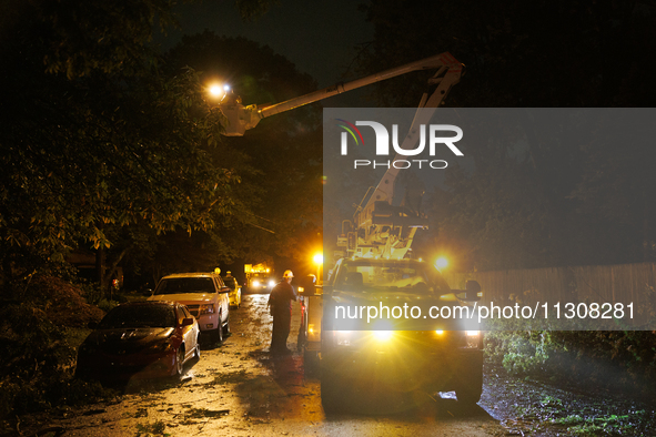 Utility crews make repairs in a Gaithersburg, Maryland neighborhood on June 5, 2024, after a tornado swept through the region. 