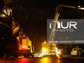 Utility crews make repairs in a Gaithersburg, Maryland neighborhood on June 5, 2024, after a tornado swept through the region. (