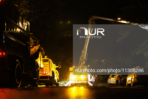 Utility crews make repairs in a Gaithersburg, Maryland neighborhood on June 5, 2024, after a tornado swept through the region. 