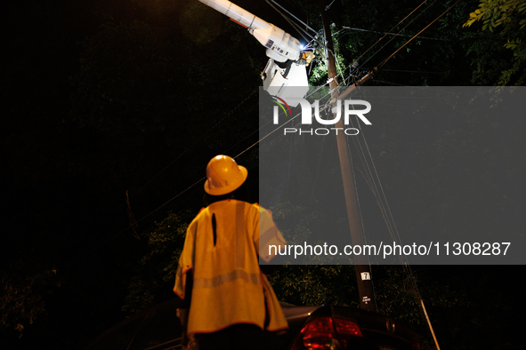 Utility crews make repairs in a Gaithersburg, Maryland neighborhood on June 5, 2024, after a tornado swept through the region. 