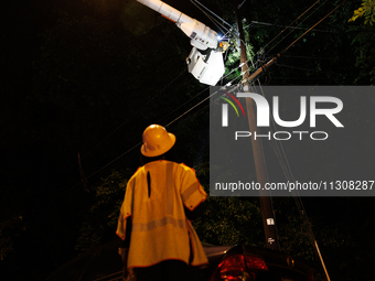 Utility crews make repairs in a Gaithersburg, Maryland neighborhood on June 5, 2024, after a tornado swept through the region. (