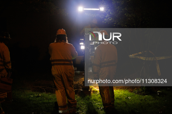 Workers from Washington Gas dig a hole on a property that was destroyed by a fallen tree in Gaithersburg, Maryland on June 5, 2024, after a...