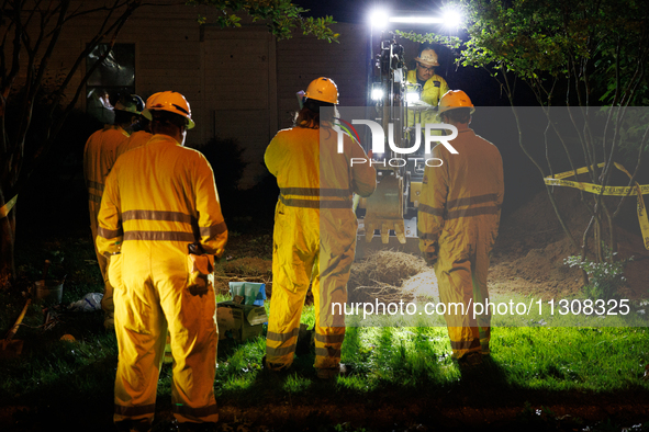 Workers from Washington Gas dig a hole on a property that was destroyed by a fallen tree in Gaithersburg, Maryland on June 5, 2024, after a...