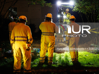 Workers from Washington Gas dig a hole on a property that was destroyed by a fallen tree in Gaithersburg, Maryland on June 5, 2024, after a...