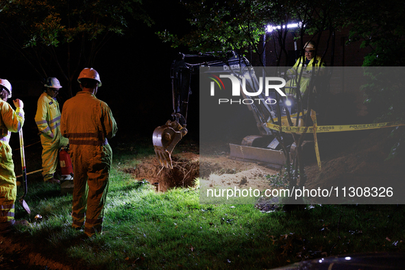 Workers from Washington Gas dig a hole on a property that was destroyed by a fallen tree in Gaithersburg, Maryland on June 5, 2024, after a...