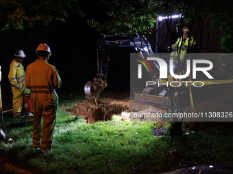 Workers from Washington Gas dig a hole on a property that was destroyed by a fallen tree in Gaithersburg, Maryland on June 5, 2024, after a...