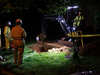 Workers from Washington Gas dig a hole on a property that was destroyed by a fallen tree in Gaithersburg, Maryland on June 5, 2024, after a...