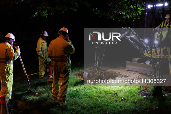 Workers from Washington Gas dig a hole on a property that was destroyed by a fallen tree in Gaithersburg, Maryland on June 5, 2024, after a...