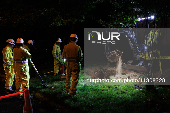 Workers from Washington Gas dig a hole on a property that was destroyed by a fallen tree in Gaithersburg, Maryland on June 5, 2024, after a...