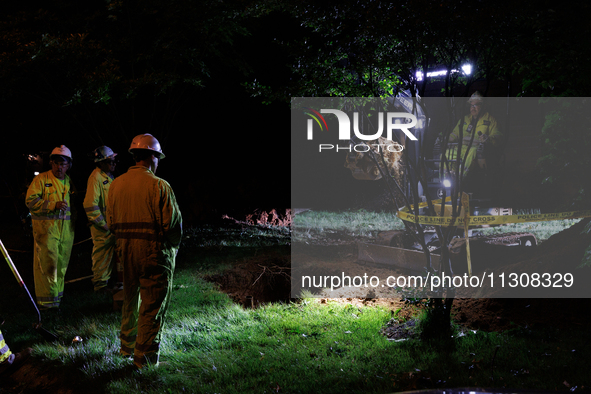 Workers from Washington Gas dig a hole on a property that was destroyed by a fallen tree in Gaithersburg, Maryland on June 5, 2024, after a...