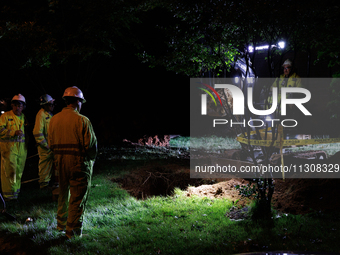 Workers from Washington Gas dig a hole on a property that was destroyed by a fallen tree in Gaithersburg, Maryland on June 5, 2024, after a...