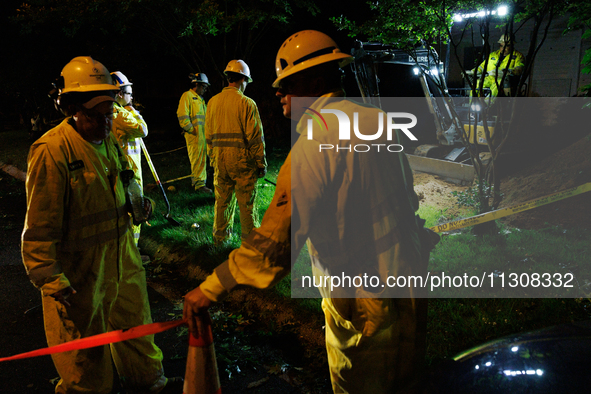 Workers from Washington Gas dig a hole on a property that was destroyed by a fallen tree in Gaithersburg, Maryland on June 5, 2024, after a...