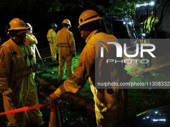 Workers from Washington Gas dig a hole on a property that was destroyed by a fallen tree in Gaithersburg, Maryland on June 5, 2024, after a...