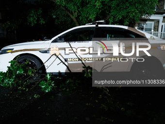 Debris lies around a Montgomery County Police vehicle after a tornado swept through a Gaithersburg, Maryland neighborhood on June 5, 2024. (