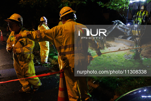 Workers from Washington Gas dig a hole on a property that was destroyed by a fallen tree in Gaithersburg, Maryland on June 5, 2024, after a...