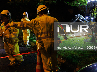 Workers from Washington Gas dig a hole on a property that was destroyed by a fallen tree in Gaithersburg, Maryland on June 5, 2024, after a...