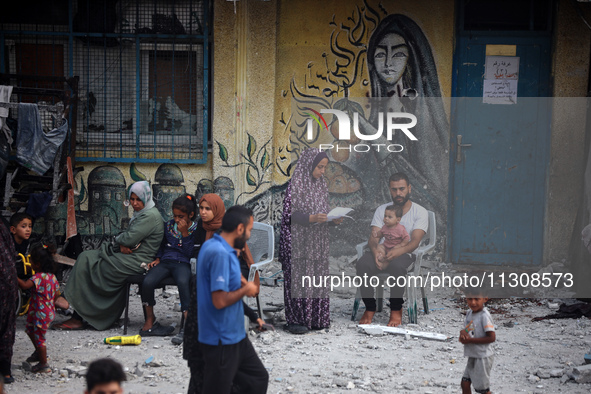 Palestinians are gathering at a UN-school that was hit during Israeli bombardment in Nuseirat, in the central Gaza Strip, on June 6, 2024, a...