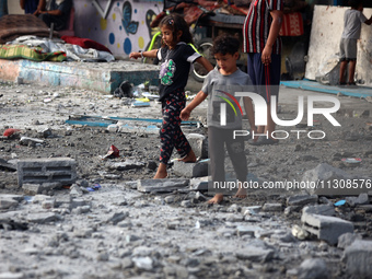 Palestinians are gathering at a UN-school that was hit during Israeli bombardment in Nuseirat, in the central Gaza Strip, on June 6, 2024, a...