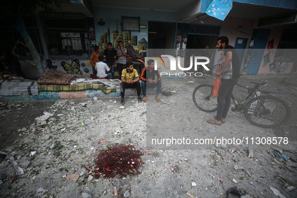 Palestinians are gathering at a UN-school that was hit during Israeli bombardment in Nuseirat, in the central Gaza Strip, on June 6, 2024, a...