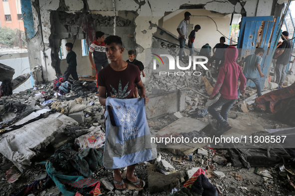 Palestinians are checking a UN-school that was hit during Israeli bombardment in Nuseirat, in the central Gaza Strip, on June 6, 2024, amid...