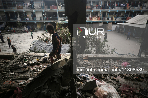 Palestinians are checking a UN-school that was hit during Israeli bombardment in Nuseirat, in the central Gaza Strip, on June 6, 2024, amid...