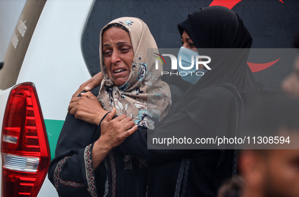 Relatives are mourning over the bodies of people killed in an Israeli airstrike at a UN school housing displaced Palestinians in Nuseirat, a...