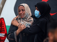 Relatives are mourning over the bodies of people killed in an Israeli airstrike at a UN school housing displaced Palestinians in Nuseirat, a...