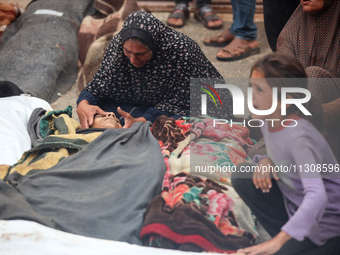 Relatives are mourning over the bodies of people killed in an Israeli airstrike at a UN school housing displaced Palestinians in Nuseirat, a...